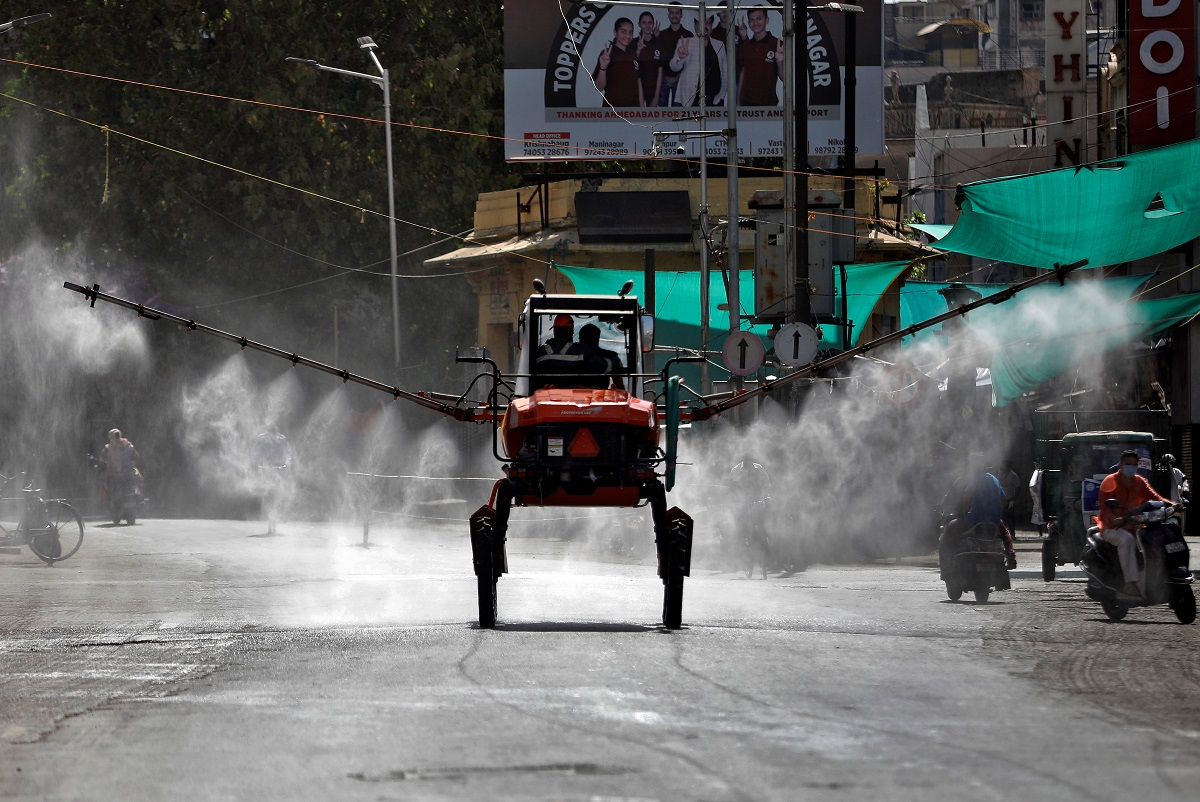 کورونا وائرس کے پھیلاؤکو روکنے کے لیے گجرات کے احمدآباد شہر میں چھڑکاؤ کرتے اہلکار۔ (فوٹو: رائٹرس)