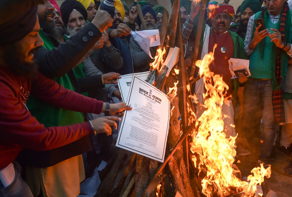 دہلی کے سنگھو بارڈر پر بدھ کوزرعی قوانین کی کاپیاں جلاتے کسان۔ (فوٹو: پی ٹی آئی)