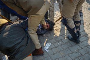 دہلی کے سنگھو بارڈر پر ہوئی جھڑپ کے دوران ایک نوجوان کو پیٹتی پولیس۔ نوجوان پر ایک ایس ایچ او پر حملہ کرنے کا الزام  ہے۔ (فوٹو:  پی ٹی آئی)